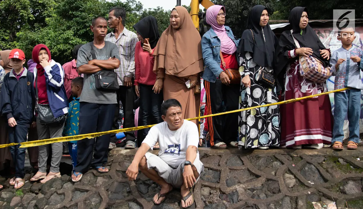 Warga melihat proses evakuasi KRL yang anjlok di kawasan Kebon Pedes, Bogor, Jawa Barat, Minggu (10/3). Kepala Daop I Jakarta Dadan Risdiansyah memastikan penanganan KRL yang anjlok selesai hari ini. (Liputan6.com/Immanuel Antonius)