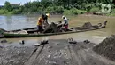 Aktivitas penambang saat bongkar muat pasir dari perahu di Sungai Klawing, Desa Toyarejo, Purbalingga, Jawa Tengah, Minggu (15/5/2022). Aktivitas penambang pasir di Sungai Klawing sudah ada sejak puluhan tahun lalu dengan menggunakan perahu dan dikerjakaan masih secara tradisional. (merdeka.com/Iqbal S Nugroho)