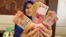 Petugas menunjukkan uang kertas rupiah di Bank BUMN, Jakarta, Selasa (17/4). Rupiah hari ini diperdagangkan dengan kisaran Rp 13.766 -Rp 13.778 per dolar AS. (Liputan6.com/Angga Yuniar)