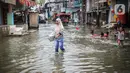 Warga beraktivitas saat banjir rob di Muara Angke, Jakarta, Jumat (25/11/2022). Badan Penanggulangan Bencana Daerah (BPBD) DKI Jakarta mengimbau agar warga di pesisir Jakarta mengantisipasi banjir pesisir atau rob selama 22-28 November 2022. (Liputan6.com/Faizal Fanani)