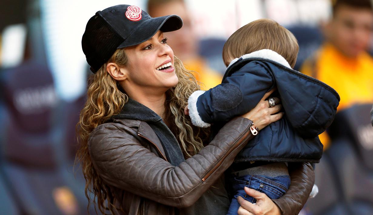Shakira, penyanyi Kolombia pasangan Gerard Pique menggendong putranya, Sasha, saat Barcelona melawan Real Sociedad dalam lanjutan La Liga Spanyol di Stadion Camp Nou, Barcelona, (28/11/2015). (EPA/Alejandro Garcia)