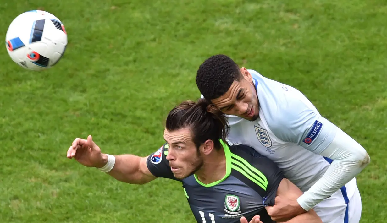 Pemain Inggris, Chris Smalling (kanan) berebut bola dengan Gareth Bale pada laga Euro 2016 grup B di Stadion Bollaert-Delelis, Lens, Kamis (16/6/2016). (AFP/Philippe Huguen)