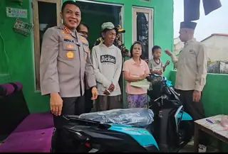 Kapolres Metro Depok Kombes Abdul Waras memberikan sepeda motor kepada penjual es kue jadul Sudrajat. (Liputan6.com/Dicky Agung Prihanto)