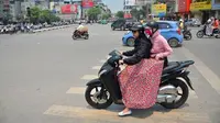 Panas terik matahari yang menyengat membuat warga Vietnam mencari berbagai cara agar tubuh serta wajah mereka terhindar dari panas.