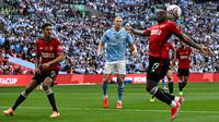 Striker Manchester City #09 Erling Haaland (tengah) melihat bek Manchester United #29 Aaron Wan-Bissaka (kanan) mengontrol bola saat ia mempertahankan gawang pada  final FA Cup 2023/2024 di Wembley Stadium, Sabtu (25/5/2024) malam WIB. (Ben Stansall / AFP)