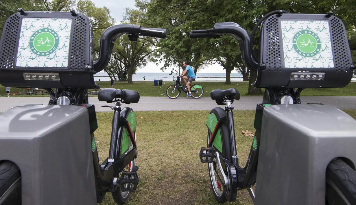 Seorang pria mengendarai sepeda sewaan melewati pos parkir sepeda di Toronto, Kanada, Rabu (2/9/2020). Mulai 2 September, pelanggan layanan penyewaan sepeda Bike Share Toronto dapat menikmati perjalanan gratis di kota tersebut setiap Rabu selama September. (Xinhua/Zou Zheng)