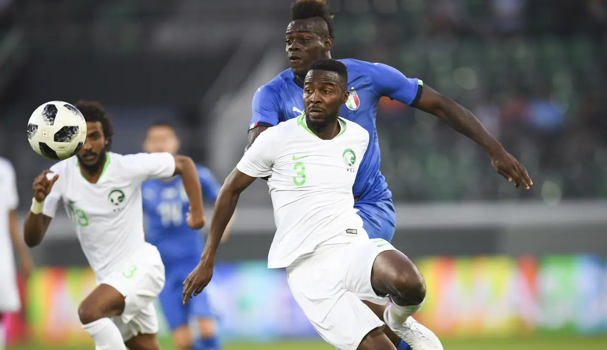 Aksi pemain Arab Saudi, Osama Hawsawi (depan) menghalau bola dari kejaran pemain Italia, Mario Balotelli pada laga persahabatan di Kybunpark Stadium, St. Gallen, Swiss, (28/5/2018). Italia menang 2-1. (Gian Ehrenzeller/Keystone via AP)