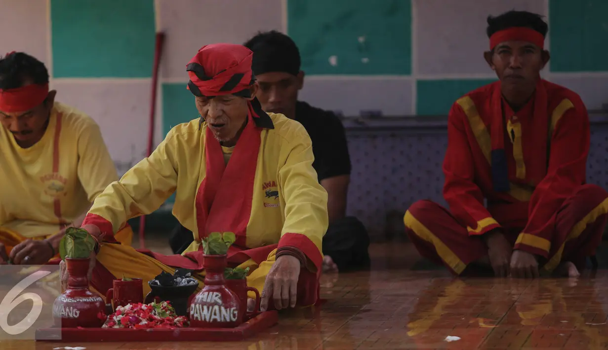 Para pawang buaya berdoa sebelum melakukan atraksi bersama buaya di Taman Wisata Buaya, Cibarusah, Jawa Barat, Minggu (26/7/2015). Atraksi berlangsung pada hari Minggu mulai dari pukul 11:00 dan 14:00. (Liputan6.com/Faizal Fanani)