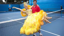 Malek Jaziri menggendong Sophia Katos saat berdansa bersama di acara promosi turnamen tenis Australia Terbuka, Melbourne Park, Kamis (22/1/2015). (Reuters/Fiona Hamilton)