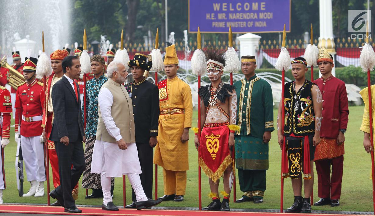 Presiden Joko Widodo (kiri) bersama PM India Narendra Modi memeriksa pasukan saat kunjungan kenegaraan di Istana Merdeka, Jakarta, Rabu (30/5). Kedatangan PM Modi ke Indonesia merupakan kunjungan resmi pertama ke Indonesia. (Liputan6.com/Angga Yuniar)