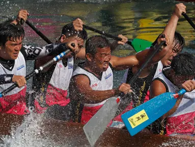 Peserta saat mengayuh perahu dalam lomba perahu naga di Hong Kong, Selasa, (30/5). Turnamen ini diselenggarakan untuk memperingati festival perahu naga yang diadakan di seluruh Hong Kong. (AP Photo / Vincent Yu)