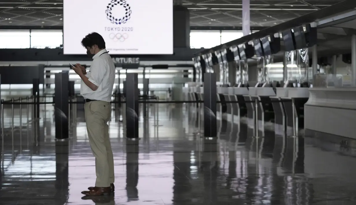 Seorang pria yang mengenakan masker untuk membantu mengekang penyebaran virus corona berdiri di konter tiket kosong pada sore hari di Bandara Internasional Narita, Tokyo, Selasa siang (1/6/2021). Perpanjangan pembatasan ini membuat sejumlah bandara terpantau sepi penumpang. (AP Photo/Eugene Hoshiko)