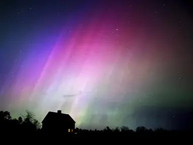 Cahaya utara atau aurora borealis menyala di langit di atas sebuah rumah pertanian, Jumat malam, 10 Mei 2024, di Brunswick, Maine, Amerika Serikat.  (AP Photo/Robert F. Bukaty)