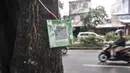 Pengendara motor melintasi pohon yang terpasang "QR code" di Jalan Ir H Juanda, Depok, Jawa Barat, Minggu (27/11/2022). Pemerintah Kota Depok memasang "QR code" pada 1.500 pohon perindang di Jalan Margonda Raya dan Jalan Ir H Juanda dengan total anggaran Rp49 juta untuk mengedukasi warga dengan informasi berupa nama pohon, nama ilmiah, umur maksimal, tinggi, lokasi, daya serap CO2 dan kode pohon untuk pendataan. (merdeka.com/Iqbal S. Nugroho)
