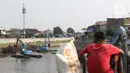Warga menyaksikan proses pengerukan endapan tanah di aliran Sungai Ciliwung, Jakarta, Selasa (28/7/2020). Pengerukan endapan ini untuk memperlancar aliran air Sungai Ciliwung serta upaya pencegahan banjir saat musim hujan. (Liputan6.com/Helmi Fithriansyah)