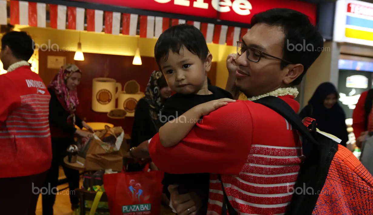 Mohammad Ahsan melepas rindu bersama anak saat tiba di Bandara Soekarno-Hatta, Cengkareng (29/8/2017). Aahsan dan Rian Agung hanya meraih medali perak pada kejuaraan dunia di Glasgow. (Bola.com/Nicklas Hanoatubun)