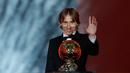 Gelandang Real Madrid, Luka Modric melambaikan tangan sambil memegang penghargaan Ballon d'Or 2018 di Grand Palais, Paris, Senin (3/12). Modric sukses memutus dominasi Cristiano Ronaldo dan Lionel Messi yang bertahan selama satu dekade (AP/Christophe Ena)