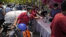 <p>Seorang pengendara sepeda motor mengambil air manis yang dibagikan oleh Sikh pada hari yang panas di New Delhi, India, Sabtu, 14 Mei 2022. Suhu di New Delhi mencapai 45 Derajat Celcius. (AP Photo/Manish Swarup)</p>