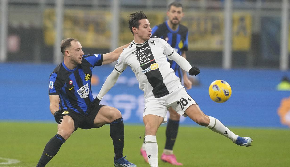 Pemain Inter Milan, Carlos Augusto, berebut bola dengan pemain Udiniese, Florian Thauvin, pada giornata ke-15 Serie A 2023/2024 di Stadion Giuseppe Meazza, Milan, Minggu (10/12/2023). (AP Photo/Antonio Calanni)