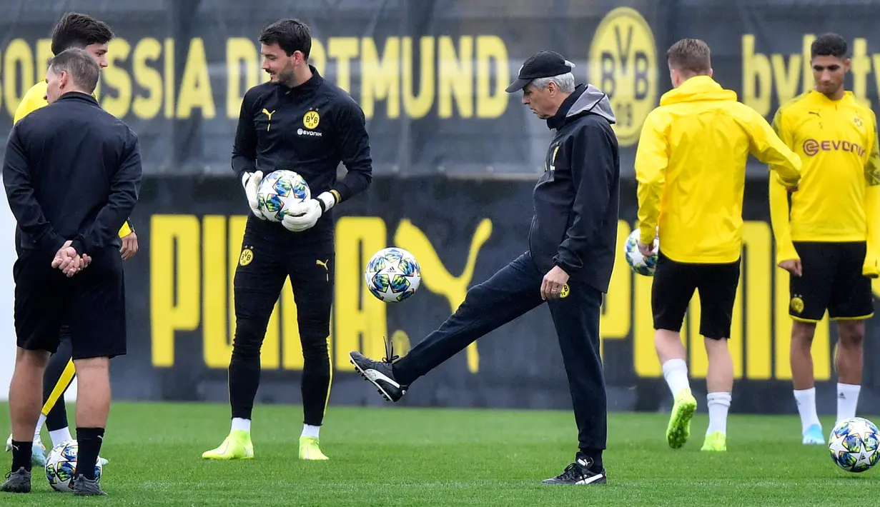 Pelatih Kepala Borussia Dortmund Lucien Favre (tengah) memainkan bola saat memimpin anak asuhnya berlatih di Dortmund, Jerman, Senin (16/9/2019). Dortmund siap menjamu Barcelona pada laga Grup F Liga Champions di Signal Iduna Park. (AP Photo/Martin Meissner)