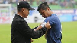 Pelatih Arema FC, Joko Susilo, menyematkan ban kapten kepada Dendi Santoso sebelum laga uji coba melawan PSIS di Stadion Gajayana, Malang, Kamis (4/1/2018). Arema FC menang 5-3 atas PSIS. (Bola.com/Iwan Setiawan)