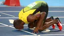 Usain Bolt mencium area lari usai meraih emas pada semifinal lari 200 meter pria di Rio de Janeiro, Brasil (17/8). Sebelumnya Usain Bolt sudah mengantongi emas di lari 100 meter di Olimpiade 2016 di Brasil. (REUTERS/Kai Pfaffenbach)