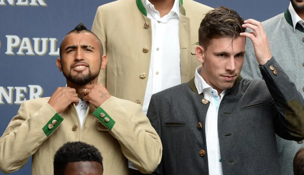 Pemain baru Munchen, Arturo Vidal, merapikan baju yang dikenakannya. (AFP Photo/Christof Stache)