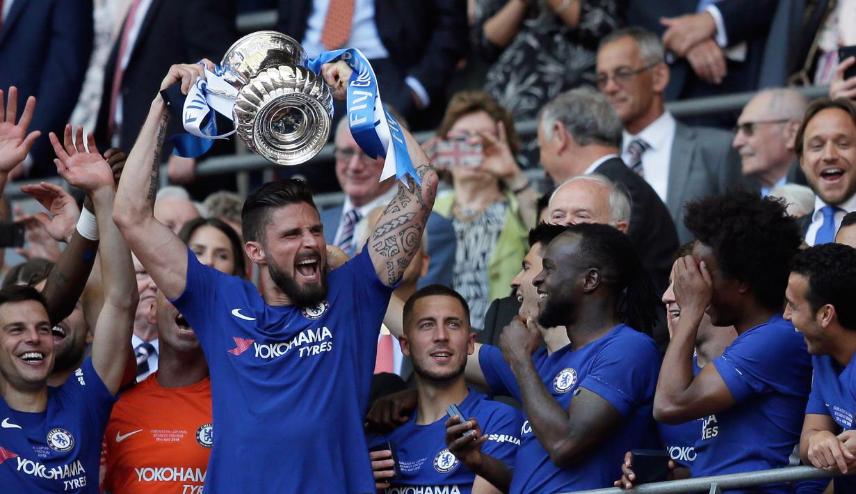 Penyerang Chelsea, Olivier Giroud mengangkat trofi Piala FA usai pertandingan melawan Manchester United pada babak final Piala FA di stadion Wembley di London (19/5). Chelsea mengalahkan MU 1-0. (AP Photo / Tim Ireland)