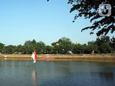 Bendera Merah Putih berdiri di tengah Waduk Cavalio, Jakarta, Jumat (4/10/2019). Dinas Sumber Daya Air DKI Jakarta mengalokasikan anggaran sebesar Rp 288,49 miliar pada 2020 untuk program naturalisasi sungai dan waduk guna mengatasi masalah banjir di Ibu Kota. (Liputan6.com/JohanTallo)