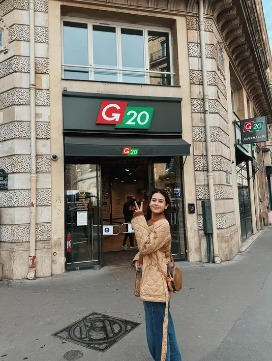 Ia mengenakan pleated long sleeve berlapis puffer coat warna cokelat dengan loose jeans yang nyaman [@maudyayunda]