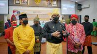 Bobby Nasution mengenakan pakaian adat Melayu lengkap dengan Tanjak berwarna kuning dipadukan sarung warna kuning pula, plus teluk belanga berwarna hitam