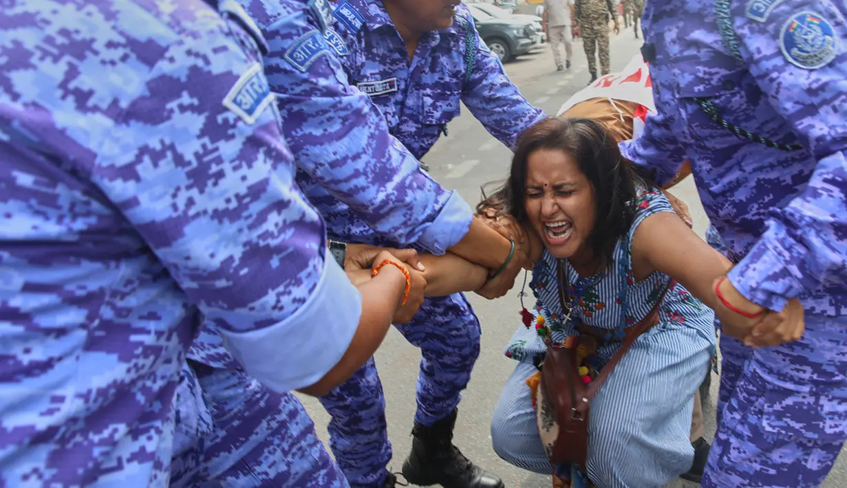 Petugas kepolisian menahan seorang demonstran saat aksi unjuk rasa yang menuntut pengunduran diri Ketua Komisi Pemilihan Umum India, Gyanesh Kumar, di New Delhi, India, Minggu (11/10/2026). (AP Photo/Prabhat Mehrota)
