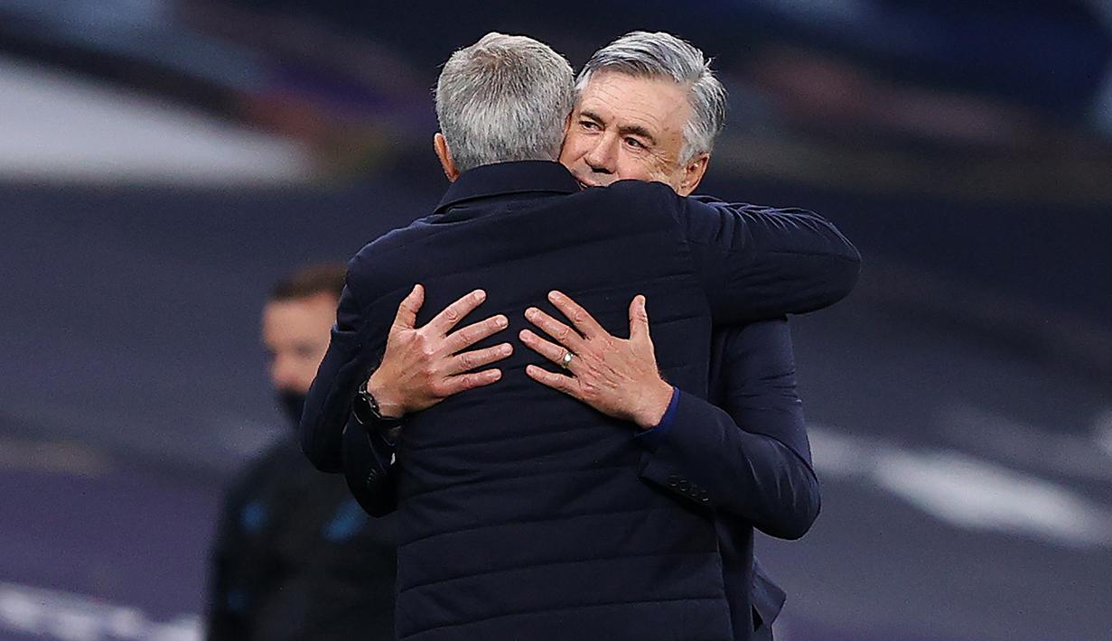 Pelatih Tottenham Hotspur, Jose Mourinho, berpelukan dengan pelatih Everton, Carlo Ancelotti, pada laga Premier League, Senin (6/7/2020). Mourinho melanggar aturan jarak sosial demi memeluk Carlo Ancelotti. (AFP/Richard Heathcote)