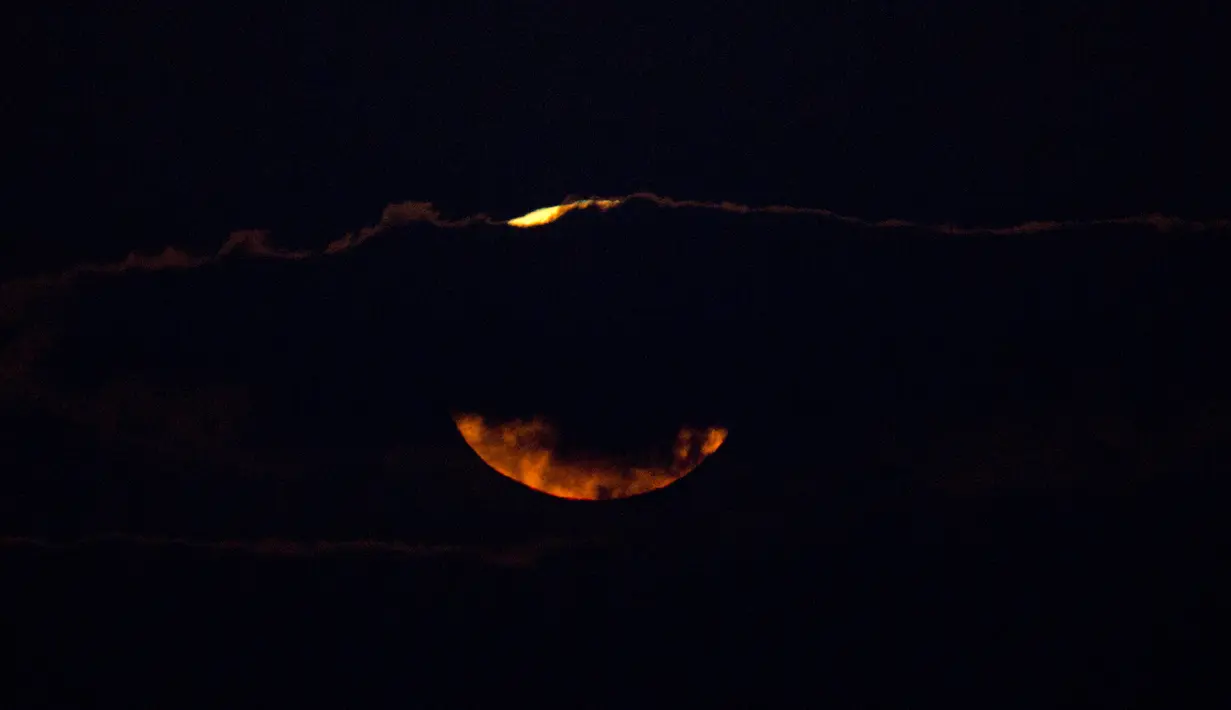 Pemadangan saat bulan terbenam di balik awan di laut Mediterania di lepas pantai Hadera, Israel, Rabu (31/1). (AP Photo / Ariel Schalit)