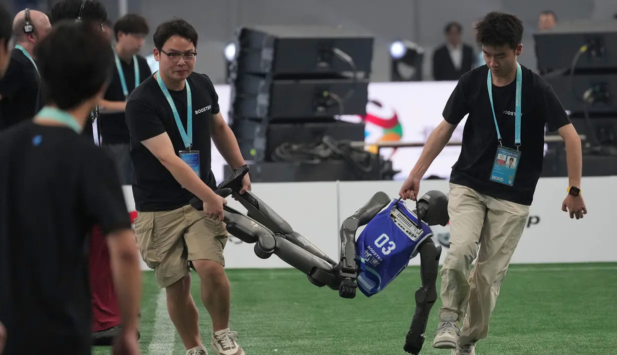 Sebuah robot humanoid dibawa keluar lapangan setelah pertandingan sepak bola menjelang upacara pembukaan World Humanoid Robot Games di Beijing, Sabtu, 22 Agustus 2026. (Foto AP/Achmad Ibrahim)