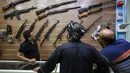 Seorang penjual, Abu Hauraa menunjukkan kepada klien berbagai macam senapan di toko senjata berlisensi miliknya di Baghdad, 24 September 2018. Setelah pelegalan senjata api untuk sipil, permintaan akan senjata api semakin meningkat. (AFP/AHMAD AL-RUBAYE)