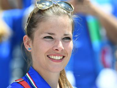 Seorang suporter cantik asal Italy tengah bersiap menyaksikan timnya melawan Swedia pada laga grup E Euro Cup 2016 di Stadion Municipal, Toulouse, Jumat (17/6/2016) WIB. (AFP/Vincenzo Pinto)