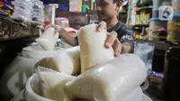 Seorang pedagang menimbang gula pasir di Pasar Kebayoran Lama, Jakarta, Selasa (21/11/2023). (Liputan6.com/Angga Yuniar)