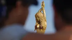 Wisatawan berfoto dengan patung Shakira di Malecon di Barranquilla, Kolombia, pada 26 Desember 2023. (STR / AFP)
