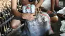 Pekerja membungkus lemang yang siap dijual di kawasan Senen, Jakarta, Selasa (30/5). Memasuki bulan Ramadan, produksi panganan khas dari Sumatera Barat tersebut meningkat 500% yang dijual seharga Rp13.000 perbuah. (Liputan6.com/Immanuel Antonius)