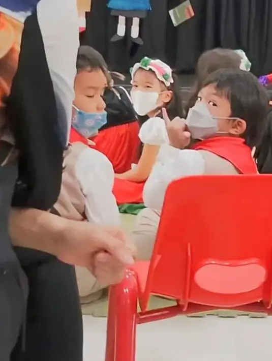 Dalam acara sekolah anak keduanya ini, terlihat Aqlan yang melihat ke hadapan orang tuanya ini memberikan tanda isyarat yang berarti I Love You. Sebuah kebiasaan simpel namun memiliki arti yang dalam dalam keluarga tentu membuat keluarga ini terlihat semakin harmonis. (Liputan6.com/IG/@mrsayudewi)