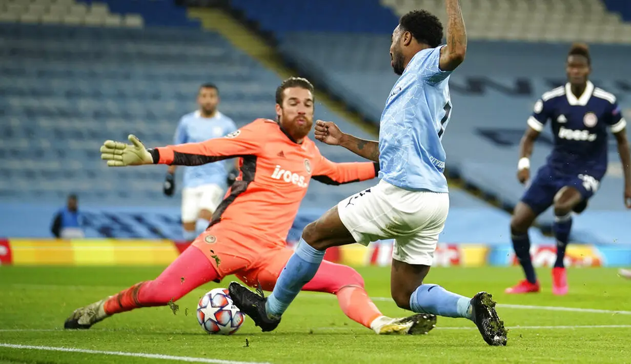 Kiper Olympiacos Jose Sa (kiri) melakukan penyelamatan di depan pemain Manchester City Raheem Sterling pada pertandingan Grup C Liga Champions di Etihad Stadium di Manchester, Inggris, Selasa (3/11/2020). Manchester City mencukur Olympiacos dengan skor 3-0. (AP Photo/Dave Thompson)