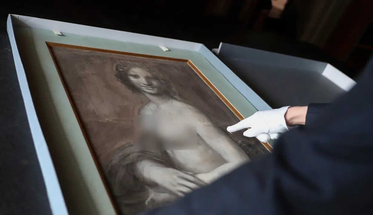 Kurator Mathieu Deldicque memegang lukisan 'Monna Vanna' atau dikenal dengan 'Mona Lisa Telanjang' di Museum Conde, Chantilly, Prancis, Senin (11/3). Para pakar memastikan lukisan tersebut diselesaikan oleh seniman kidal. (Kenzo Tribouillard/AFP)