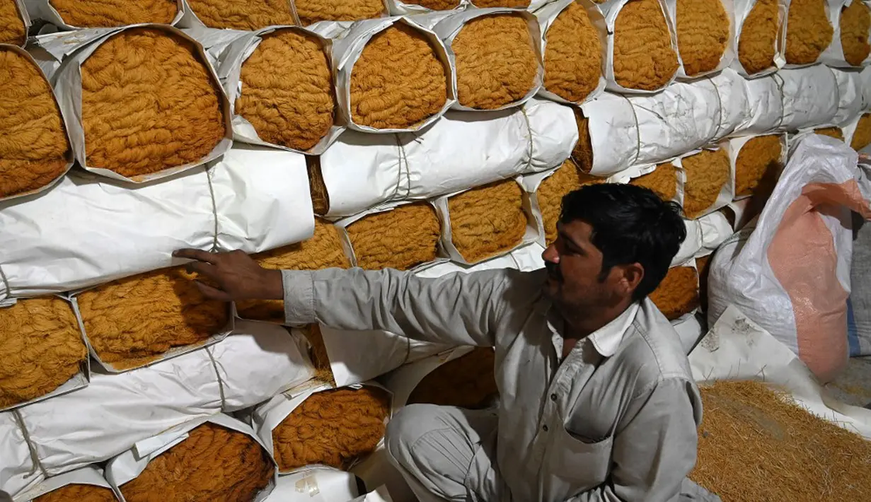 Seorang pekerja mengemas bihun yang digunakan untuk membuat hidangan manis tradisional yang populer selama bulan puasa Ramadhan, di Lahore pada 12 April 2022. (Arif ALI/AFP)