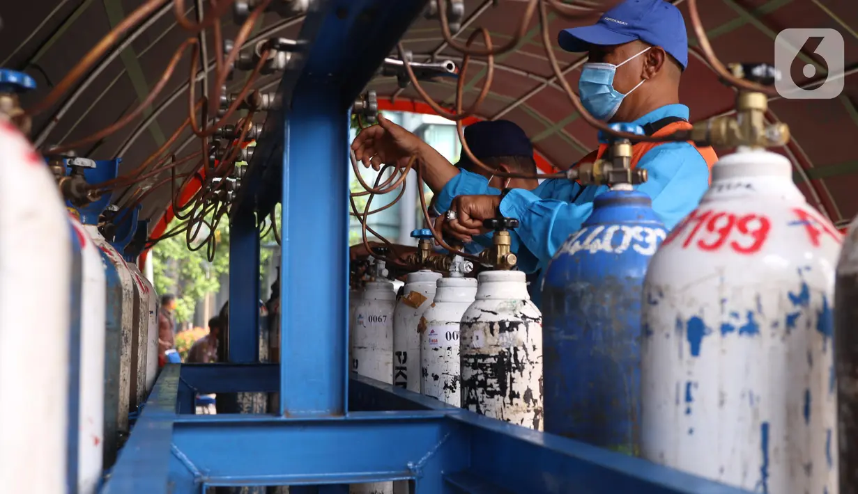 Petugas mengisi tabung oksigen di halaman gedung MUI Kota Tangerang, Banten, Kamis (15/7/2021). Kegiatan tersebut guna memudahkan warga Kota Tangerang dalam mengisi Oxygen Medis yang di masa PPKM Darurat yang kini sulit untuk mencari tempat pengisian tersebut. (Liputan6.com/Angga Yuniar)
