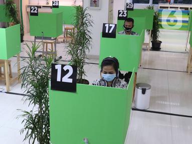 Peserta BPJAMSOSTEK berkomunikasi dengan petugas dari LAPAK ASIK (Layanan Tanpa Kontak Fisik) di Kantor Cabang Tangerang, Jumat (12/6/2020). Layanan dengan protokol kesehatan tanpa harus kontak langsung ini untuk mencegah penularan COVID-19 di masa tatanan normal baru. (Liputan6.com/Angga Yuniar)