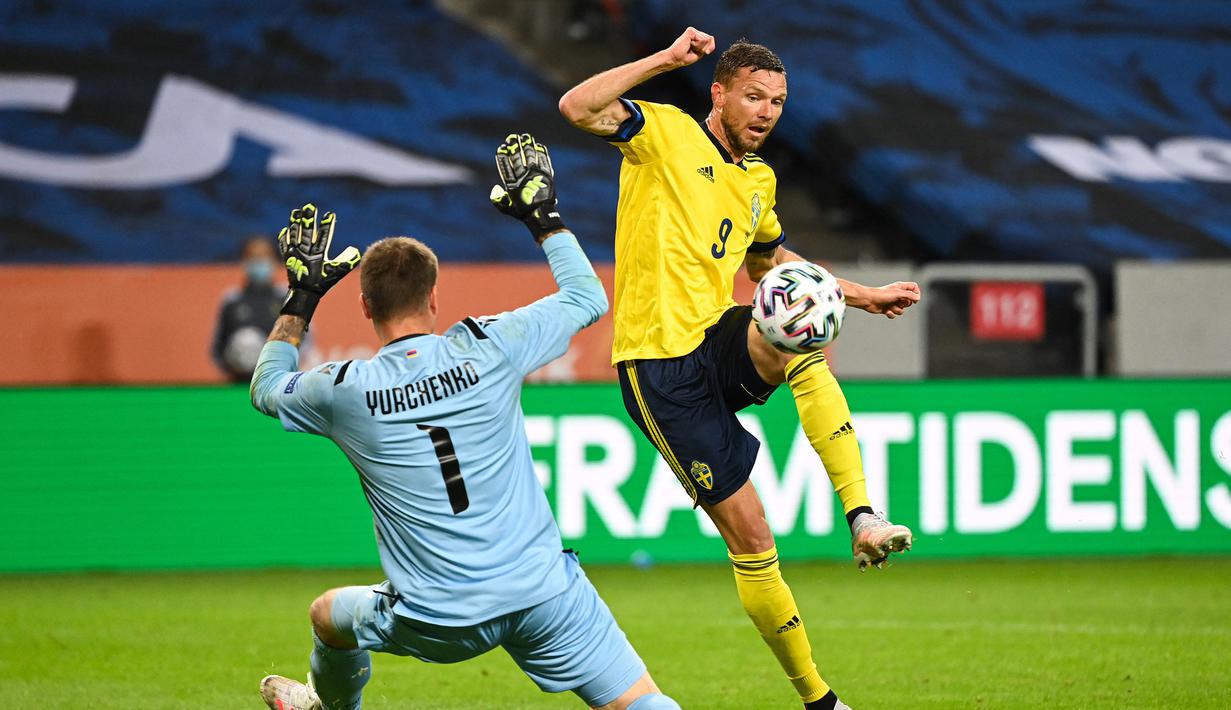 Striker Swedia, Marcus Berg (kanan) berduel dengan kiper Armenia, David Yurchenko untuk mencetak gol ketiga Swdia dalam laga uji coba menjelang berlangsungnya Euro 2020 di Solna, Sabtu (5/6/2021). Swedia menang 3-1 atas Armenia. (AFP/Jonathan Nackstrand)