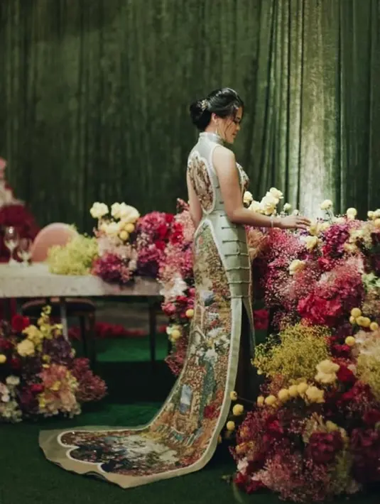 Bagian belakang dan depan gaun dihiasi sulaman gambar pemandangan, yang menambah daya tarik dalam cheongsam ini.  [Foto: IG/behind.thevows].