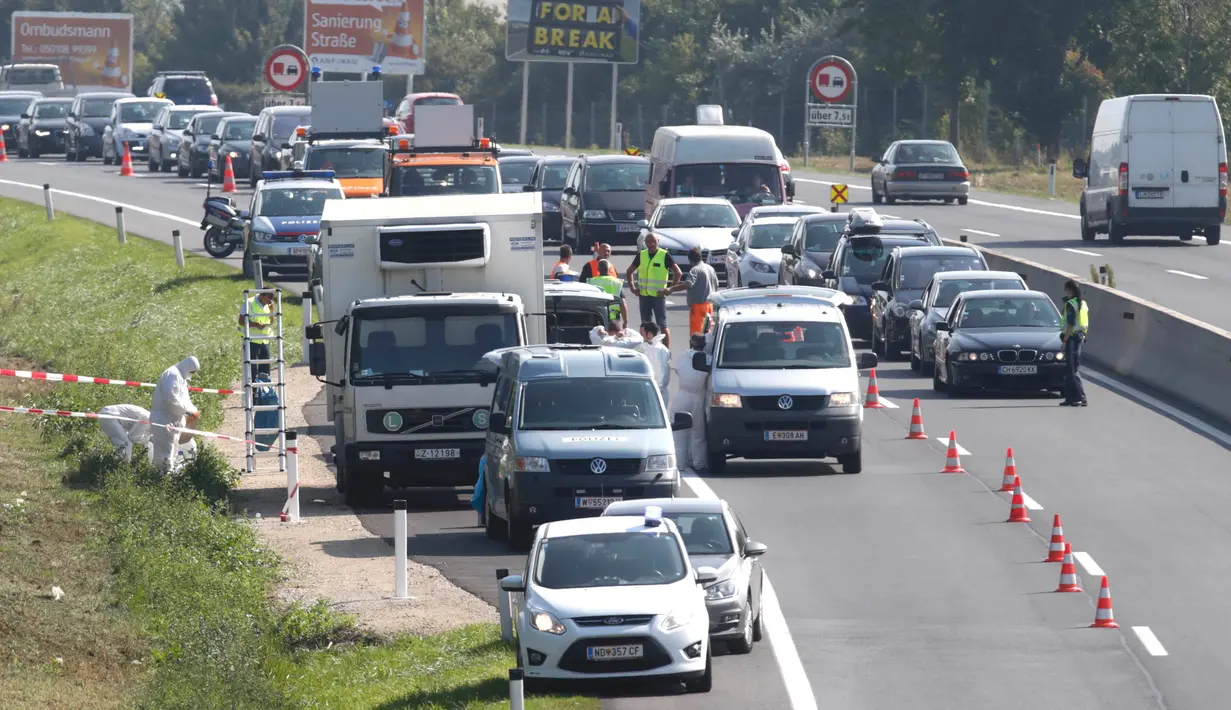 Petugas forensik memeriksa sebuah truk yang berisi sekitar 50 imigran gelap yang tewas di sebuah jalan tol di Austria, dekat perbatasan Hongaria, Kamis (27/8/2015). Indikasi awal mereka tewas karena kekurangan oksigen. (REUTERS/Heinz-Peter Bader)