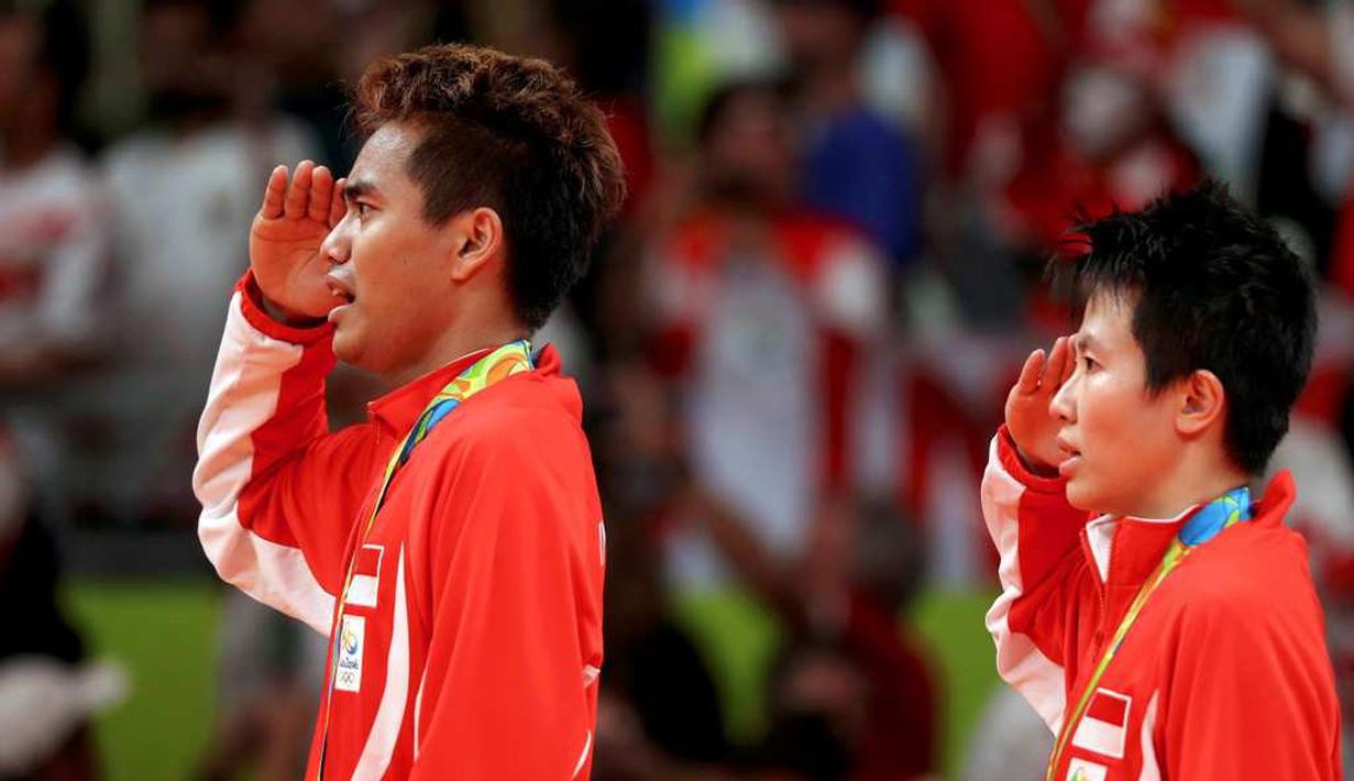 Tontowi Ahmad dan Liliyana Natsir saat memberikan hormat kepada sang Merah Putih serta menyanyikan lagu kebangsaan Indonesia Raya setelah meraih emas ganda campuran bulutangkis Olimpiade Rio 2016. (Reuters/Mike Blake)
